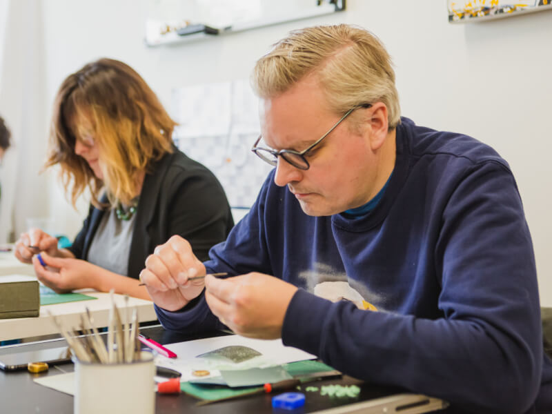 Man in a jewellery making class using tools